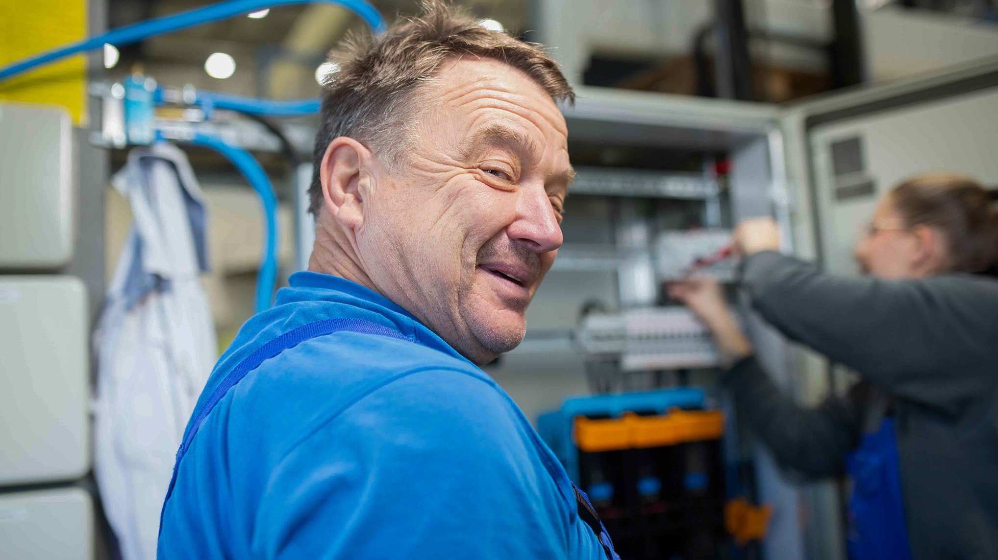 Ein Strieter Mitarbeiter blickt über die Schulter und lächelt in die Kamera