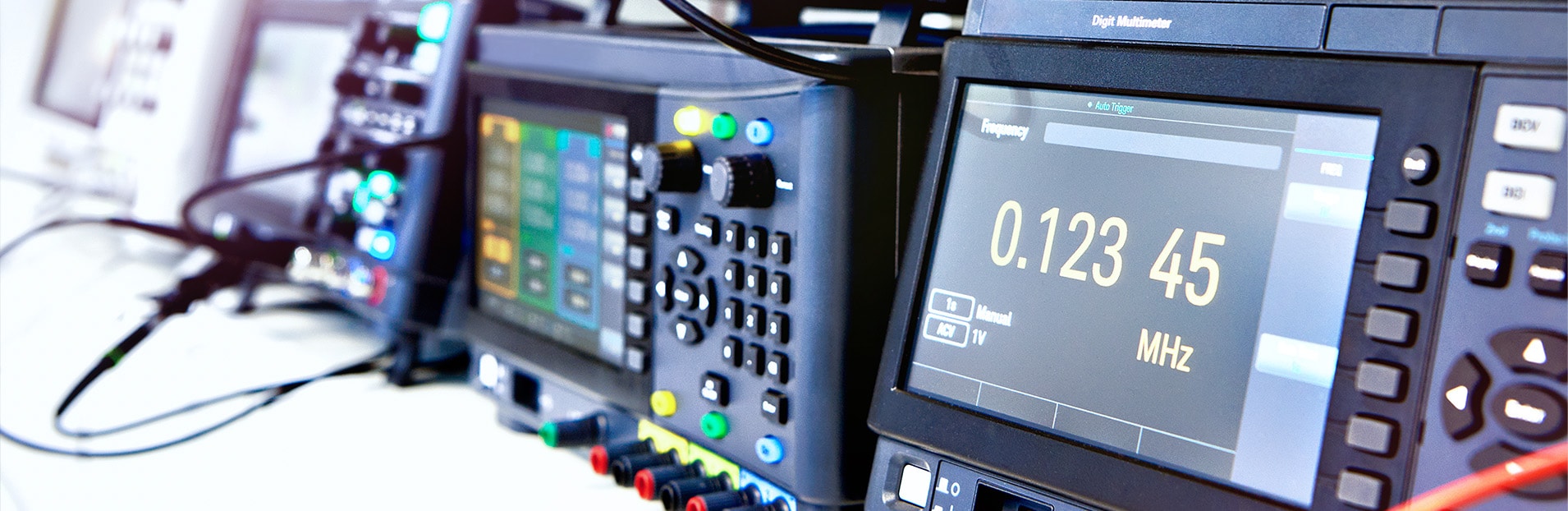 Ein Oszilloskop und andere Prüfeinrichtungen zur Lastanalyse von Stromnetzen stehen auf einem Tisch.  