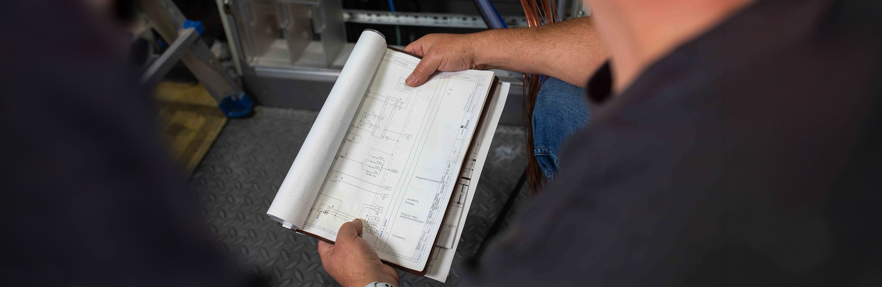 Person hält einen Schaltplan in der Hand. 