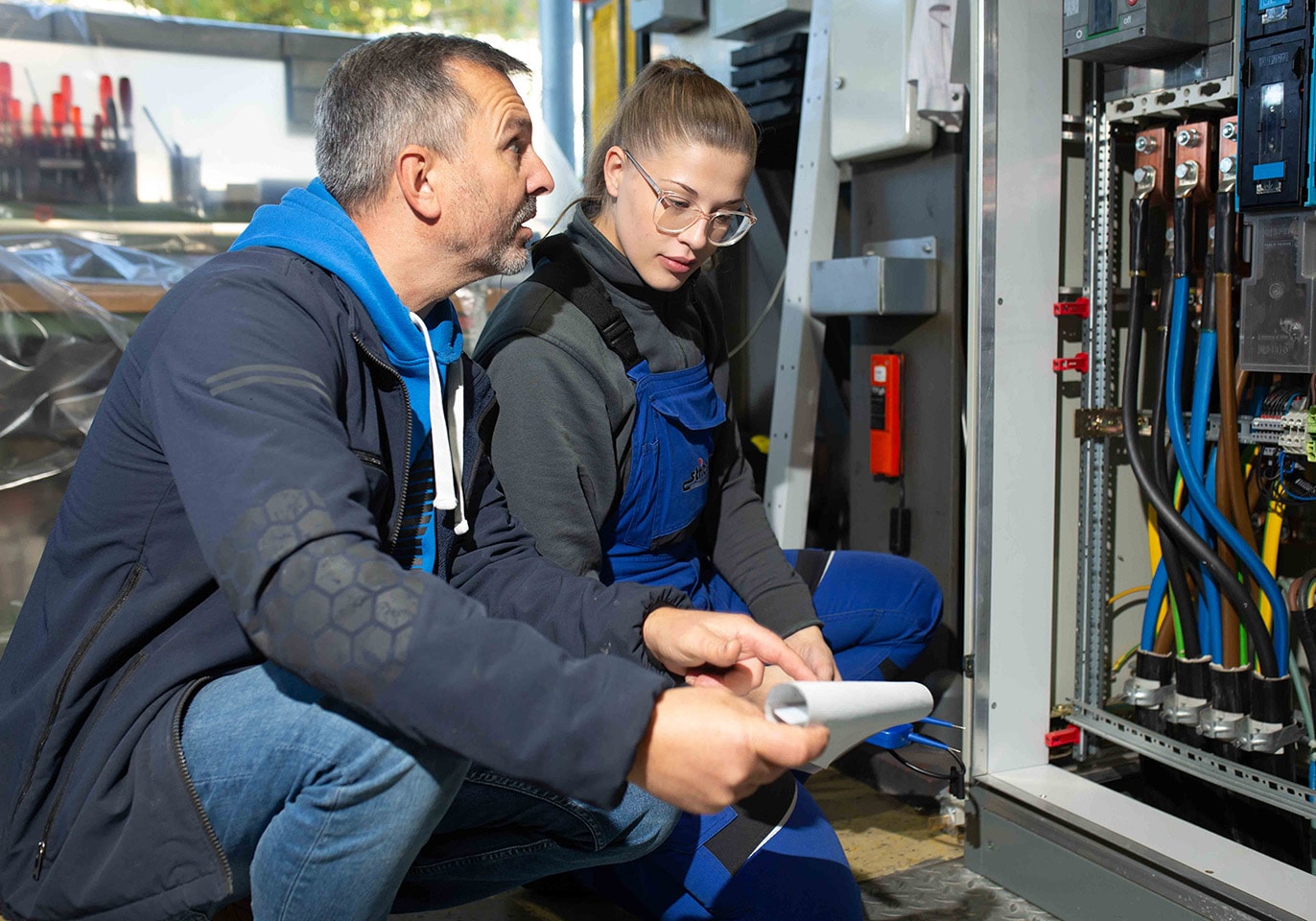 Weibliche und männliche Arbeitskollegen analysieren gemeinsam eine elektrotechnische Einrichtung