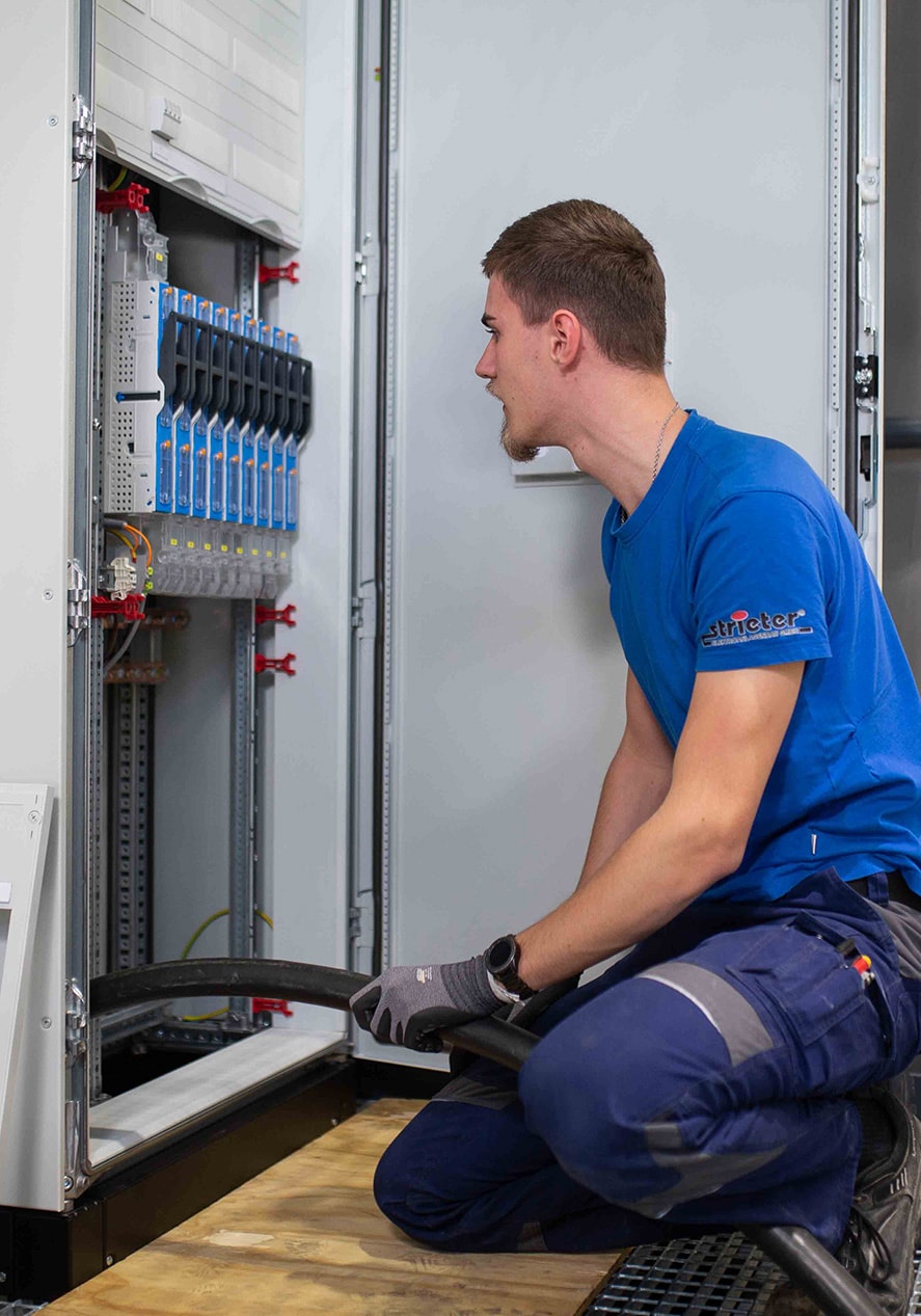 Junger Kollege prüft einen Schaltschrank