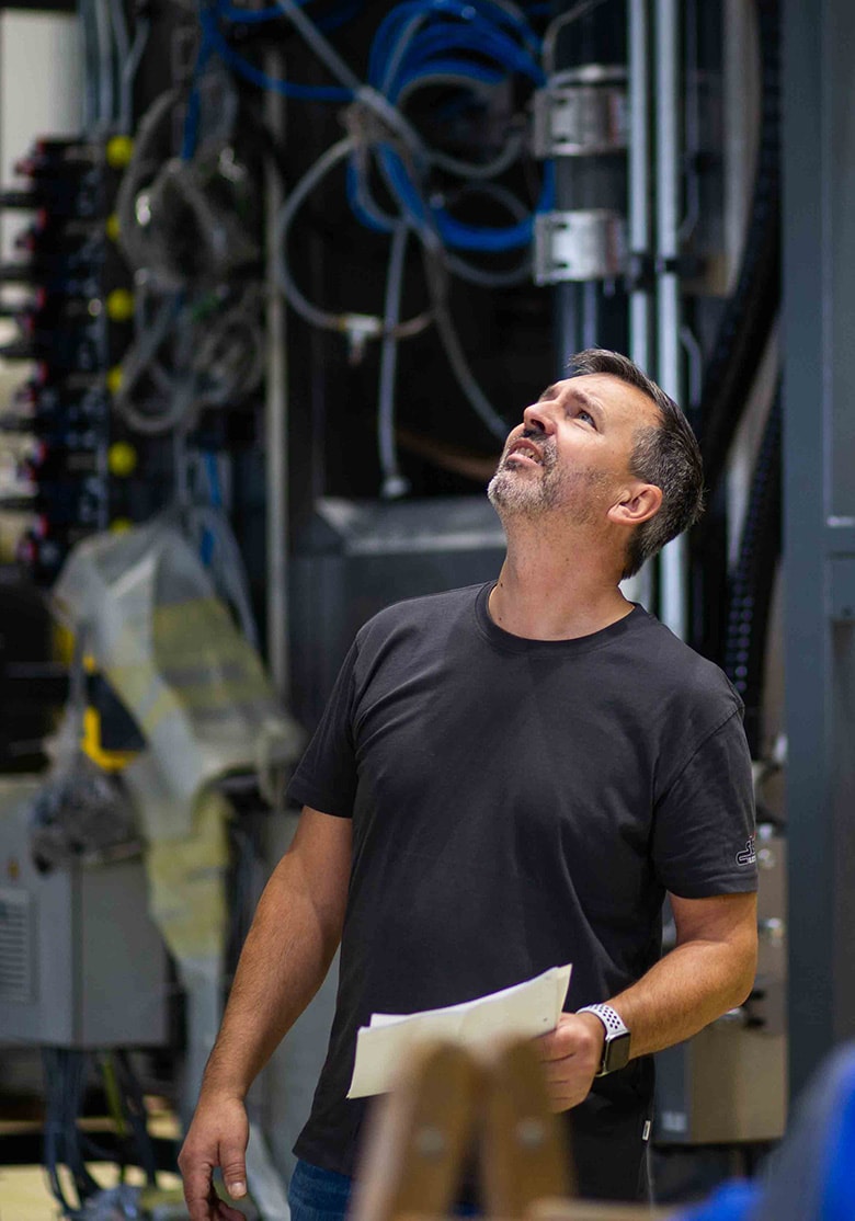 Streiter-Mitarbeiter richtet den Blick nach oben, um eine elektrotechnische Anlage unter der Decke zu prüfen