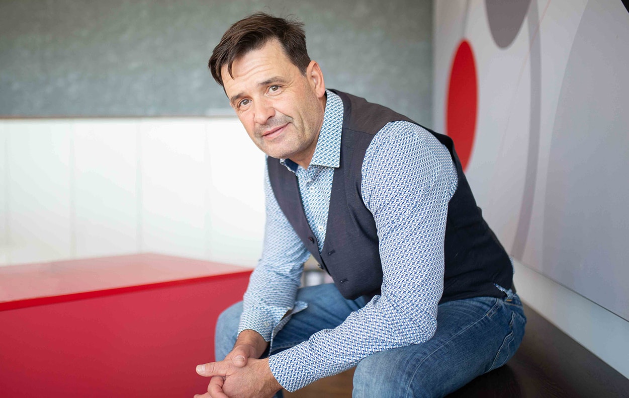 Geschäftsführer und Unternehmensinhaber Thomas Strieter sitzt in lässiger Pose und blickt freundlich in die Kamera