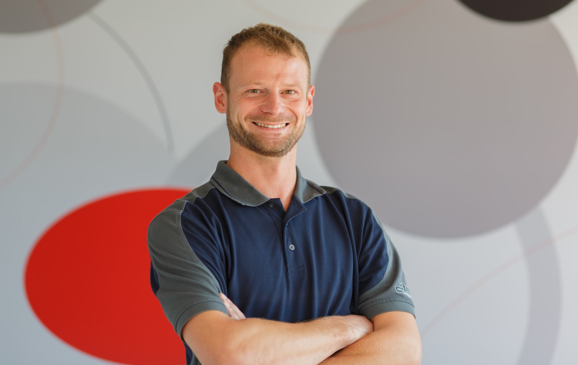 Andreas Kliem, Ansprechpartner für den Bereich Netzausbau bei Strieter Elektroanlagenbau, blickt lächelnd mit verschränkten Armen und voller Tatendrang in die Kamera.